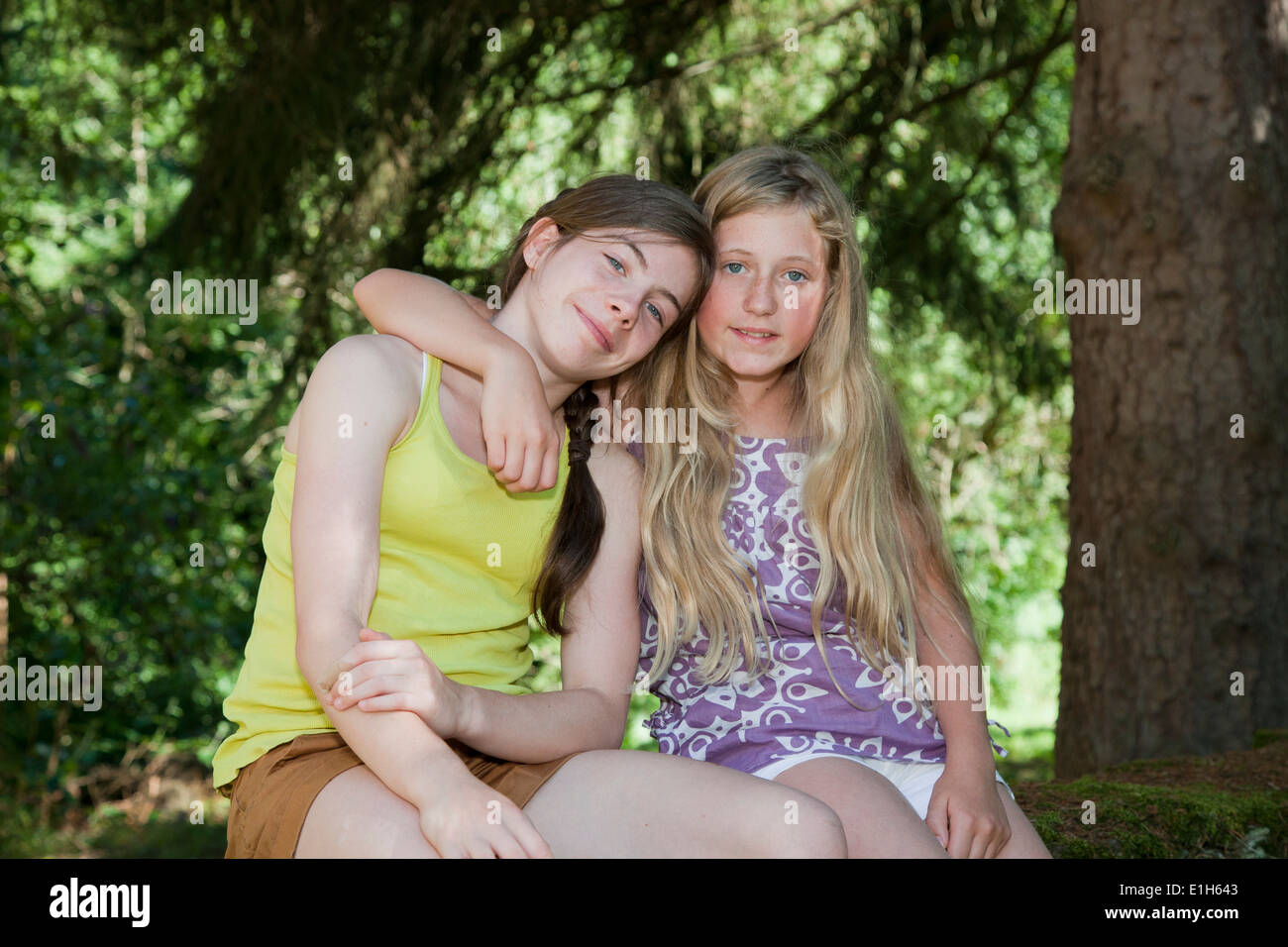Gli adolescenti seduti in giardino con braccio intorno a Foto Stock