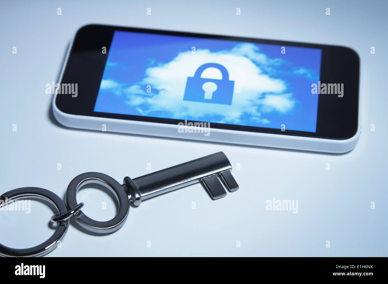 Fissare smart phone. Un tasto accanto a smartphone con una serratura su una nuvola sul suo schermo. Foto Stock