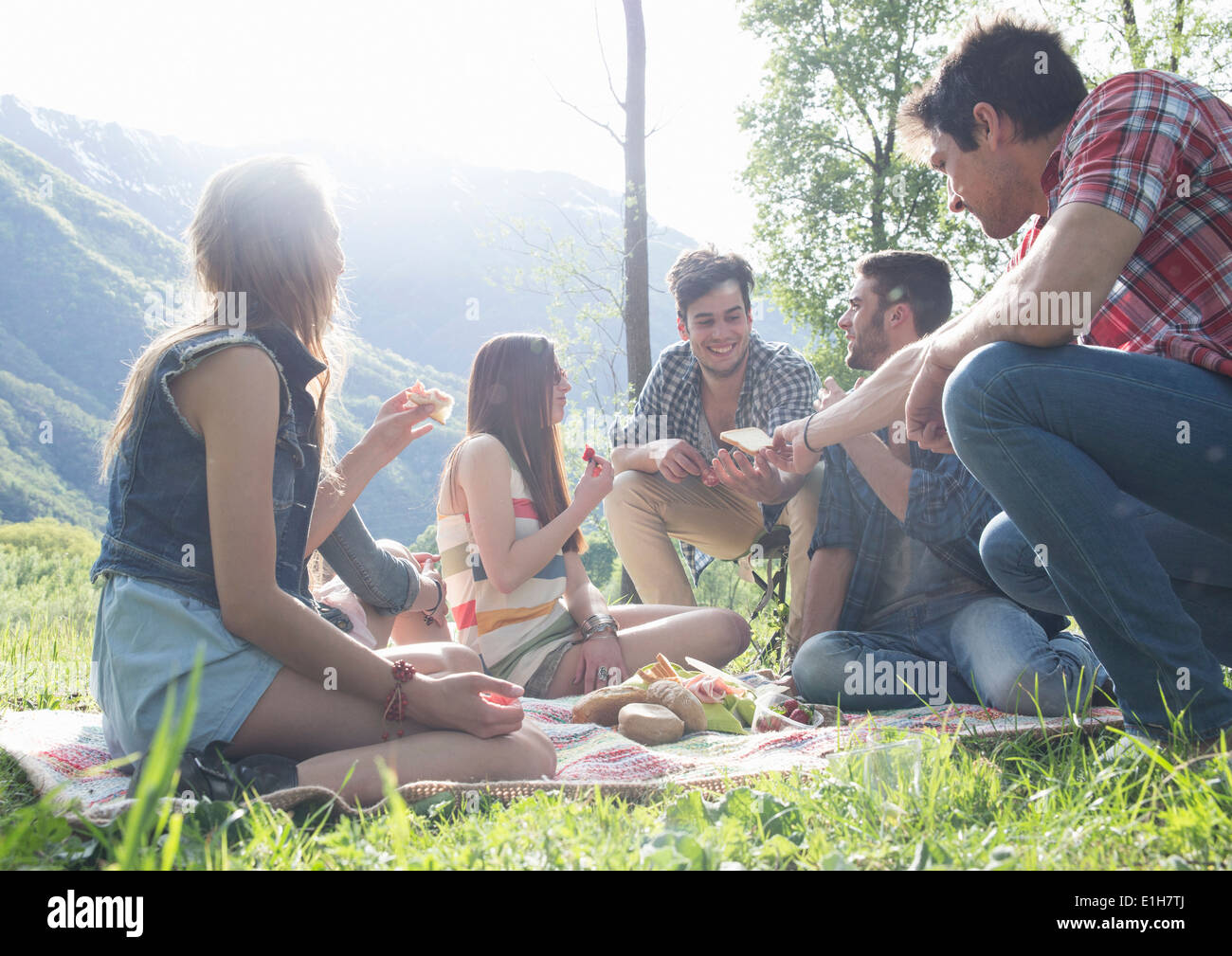 Amici seduti con picnic Foto Stock