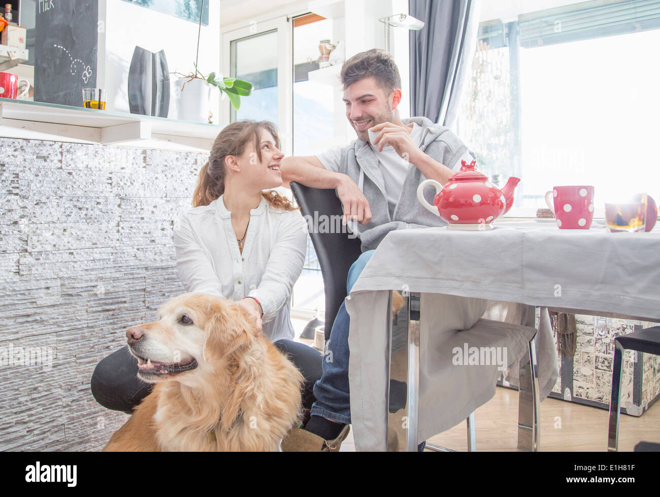 Coppia giovane avente la colazione, con il cane Foto Stock