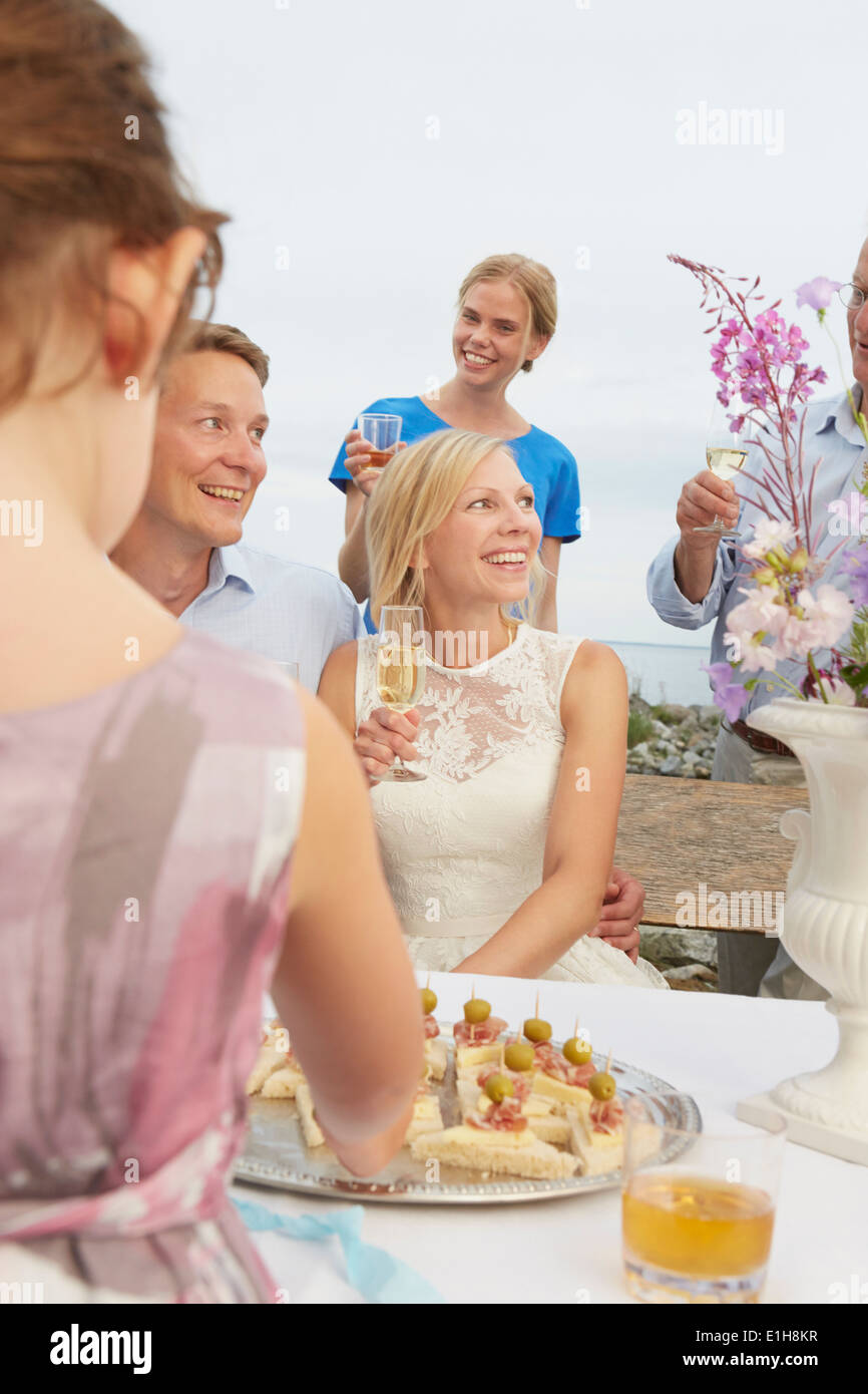 Metà adulto giovane fare un brindisi con un gruppo di amici a ricevimento di nozze Foto Stock