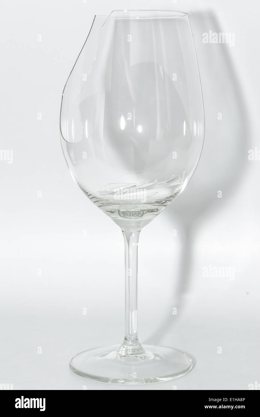 Rotto wineglass chiara con forte i frammenti di vetro interno su sfondo bianco Foto Stock