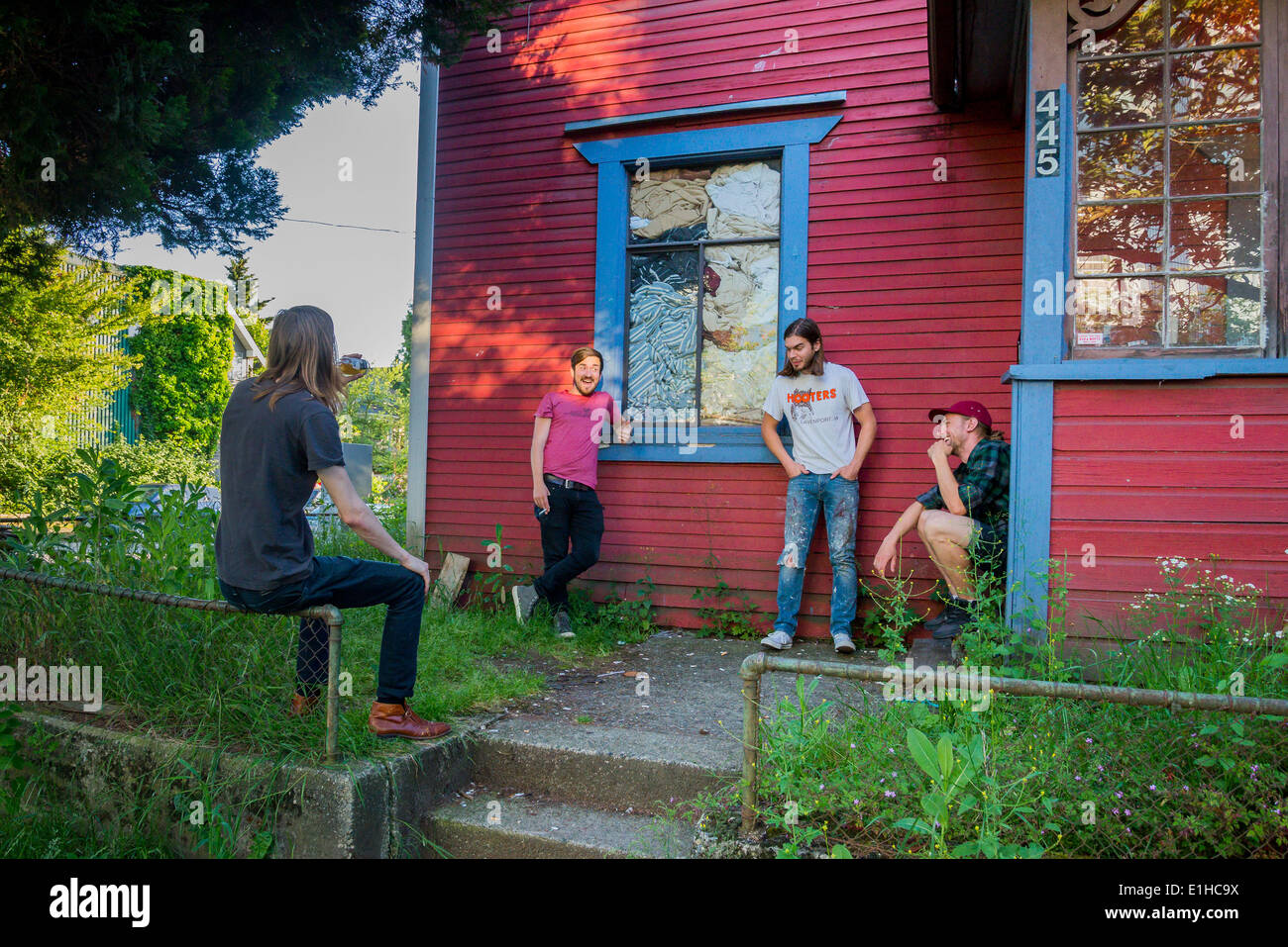 Ragazzi appendere fuori nel cortile anteriore, Strathcona quartiere, Vancouver, British Columbia, Canada Foto Stock