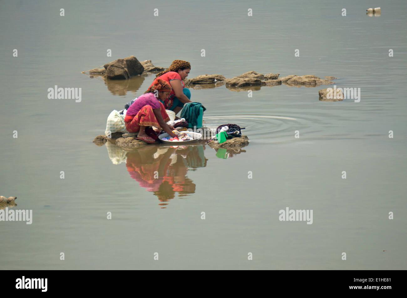 Due donne che fanno servizio lavanderia nel lago Foto Stock