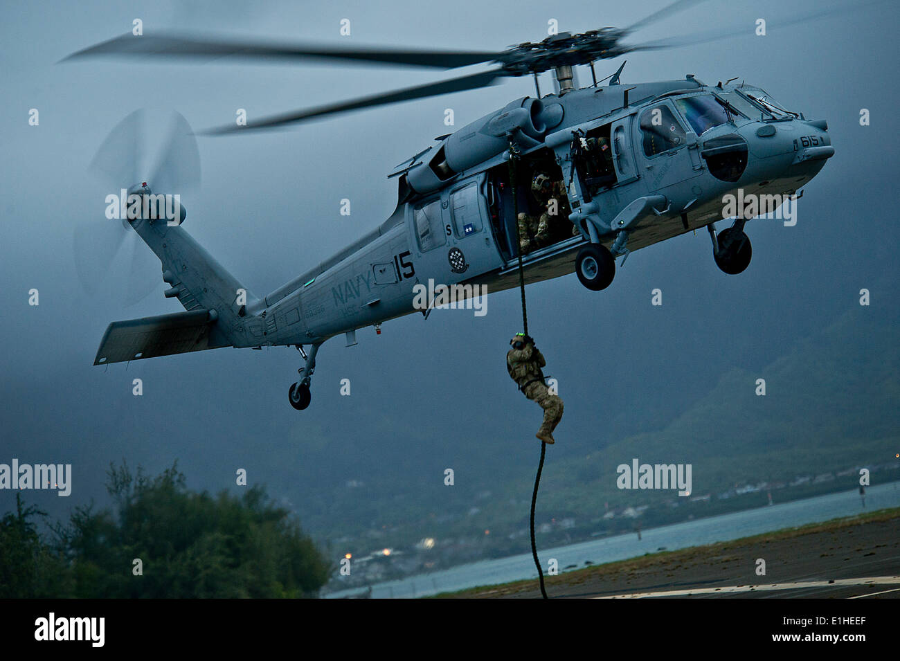 Un U.S. Sailor assegnati per l'eliminazione degli ordigni esplosivi unità mobile 11 fast-corde al di fuori di un MH-60S Knighthawk elicottero assegnato Foto Stock
