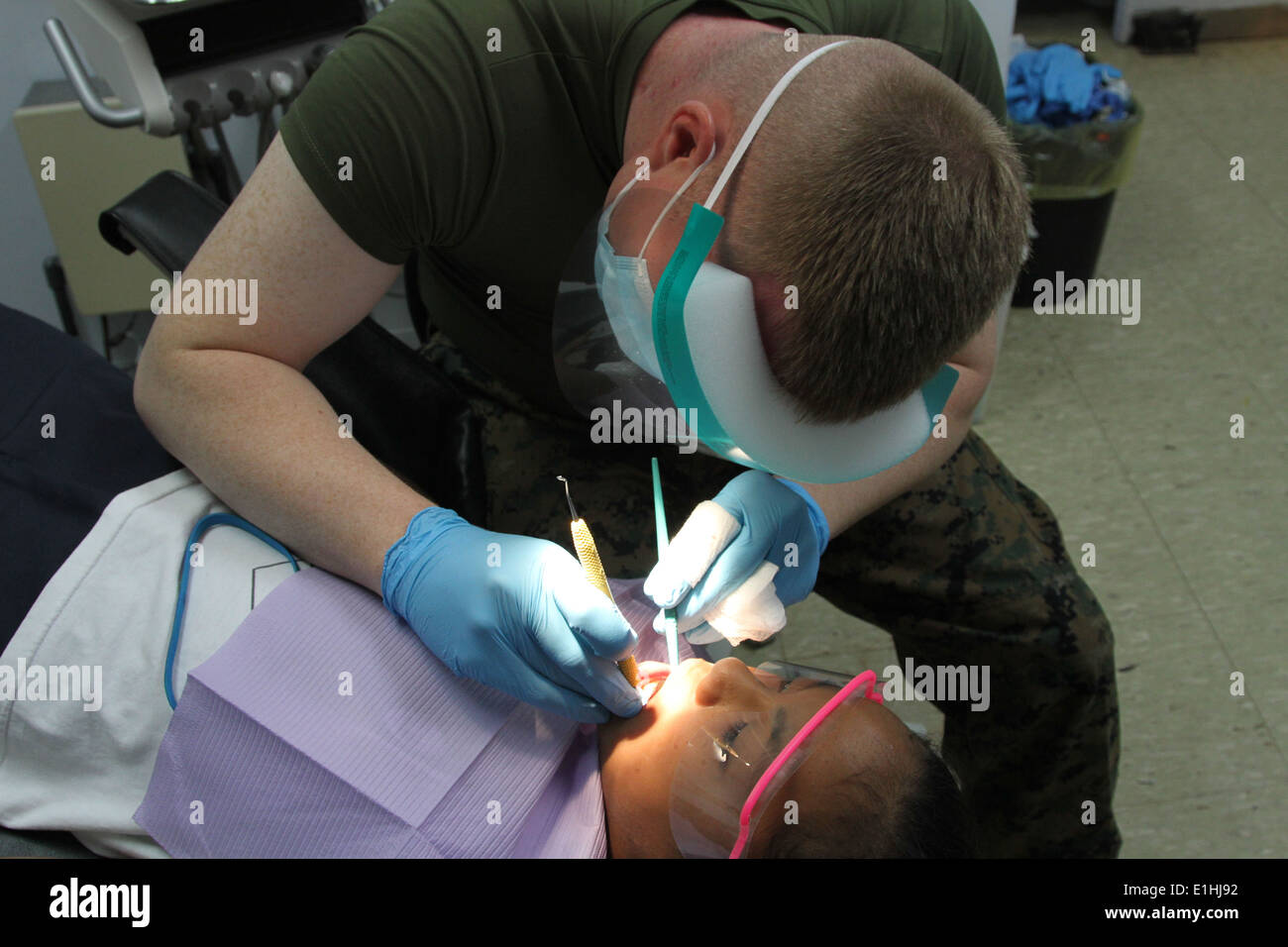 Un bambino riceve cure dentarie da U.S. Navy Seaman Jeffrey M. Ker, una chirurgia orale tecnico con l'undicesima società dentale, 3r Foto Stock