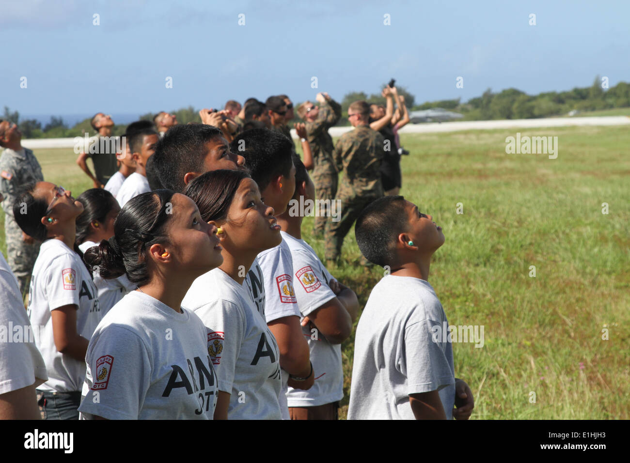 Tinian gli studenti delle scuole superiori con la scuola?s junior programma ROTC guardare come un U.S. Marine Corps F/A-18D Hornet velivolo vola ov Foto Stock