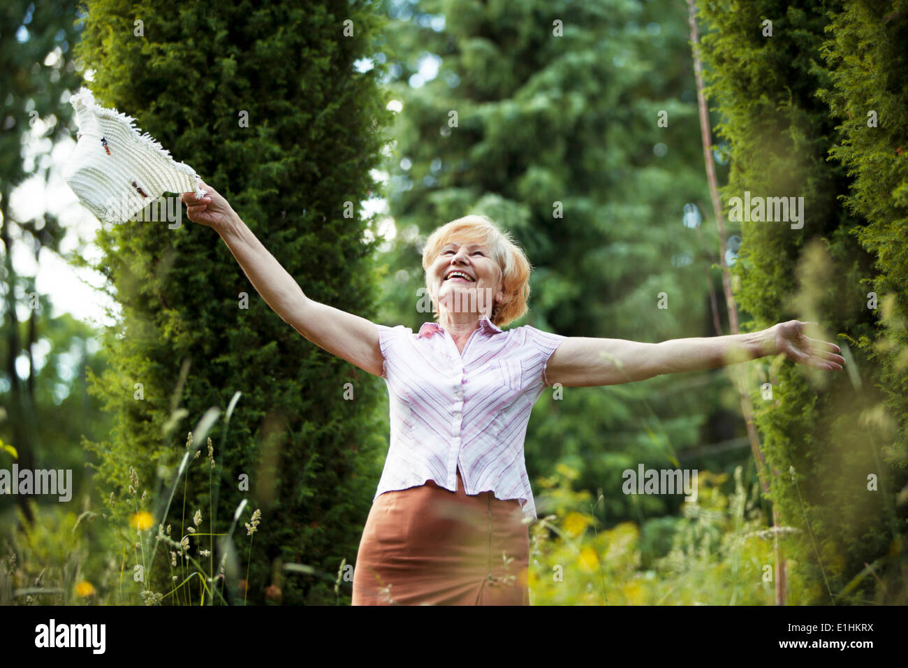 La libertà. Happy Old Lady con Capanna sorridente nel giardino. Stile di vita Foto Stock