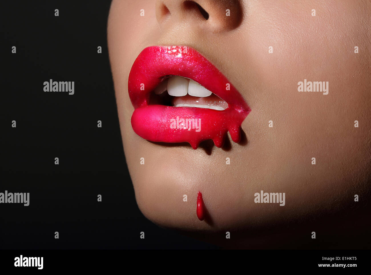 Splash. Donna di rosso le labbra con il rossetto di gocciolamento. La creatività Foto Stock