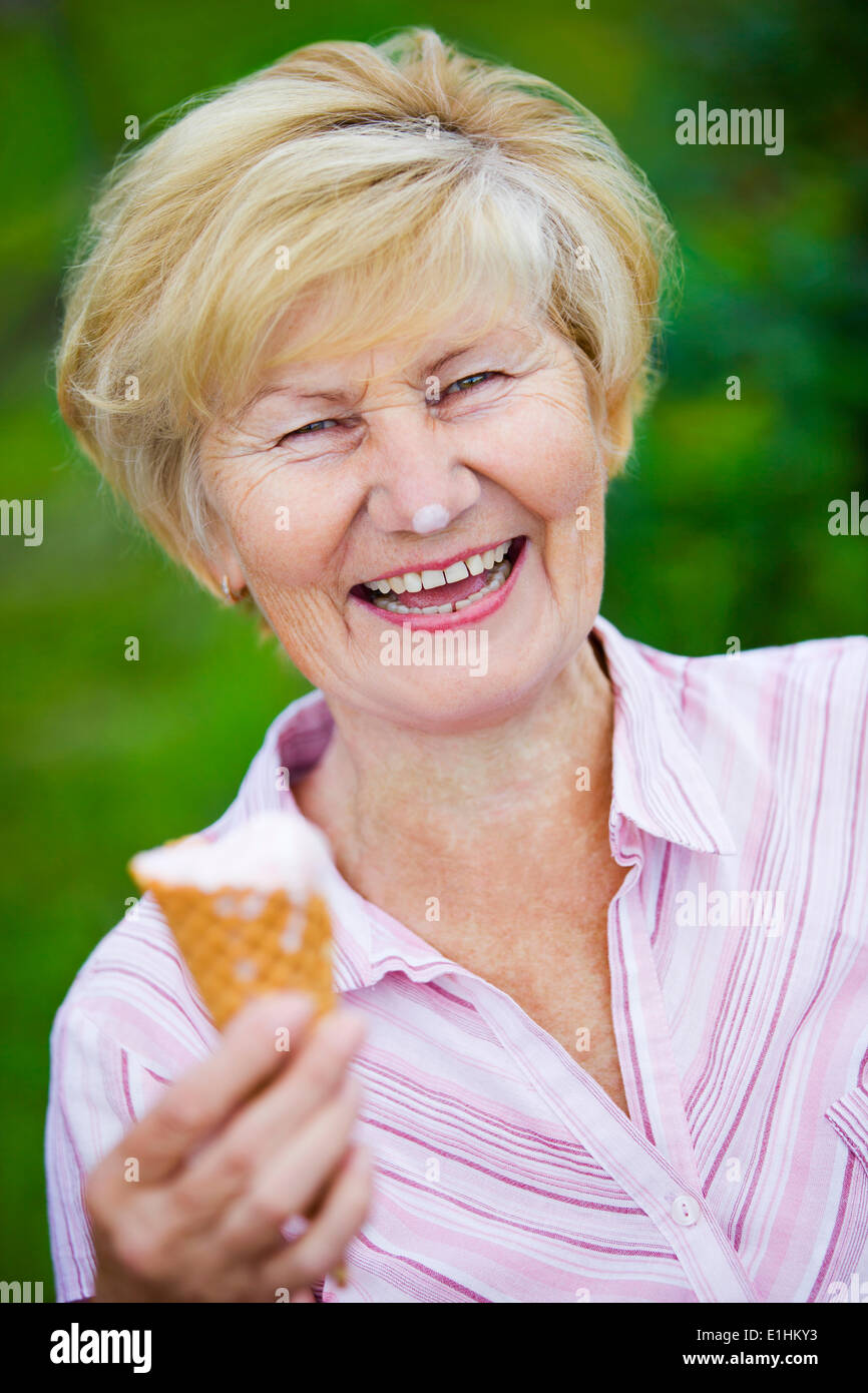 La contentezza. Giubilanti estasiato vecchia donna tenendo la Gelateria e ridere Foto Stock