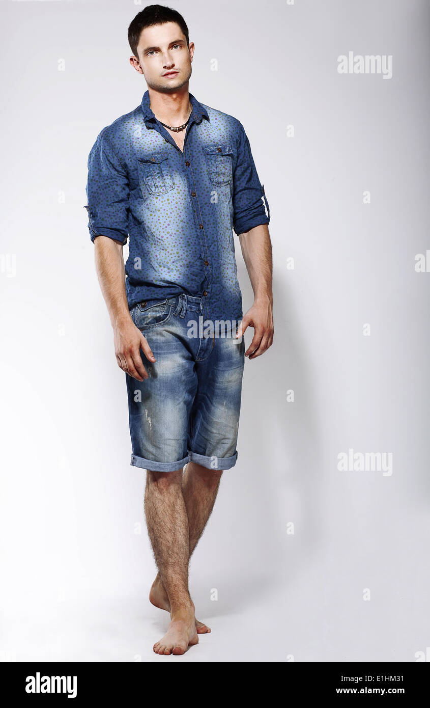 A piena lunghezza Ritratto di giovane fiducioso a piedi nudi uomo in jeans blu Foto Stock