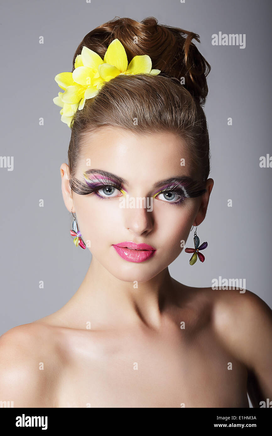 Eccentrica donna appariscente con vivaci trucco colorato e falso le ciglia lunghe Foto Stock