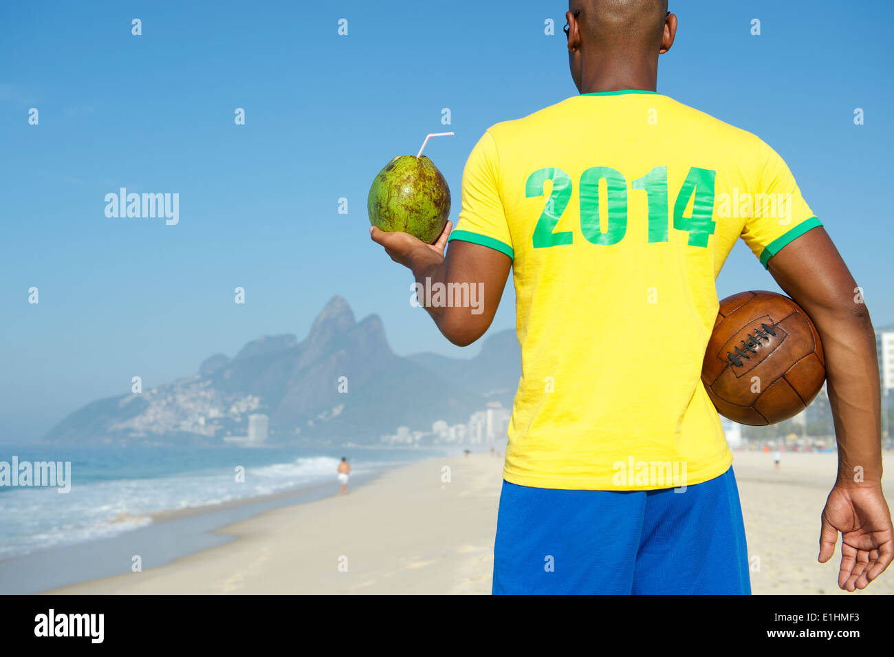 Il calcio brasiliano giocatore indossa 2014 shirt in Brasile colori azienda vintage soccer ball cocco potabile Rio de Janeiro Foto Stock