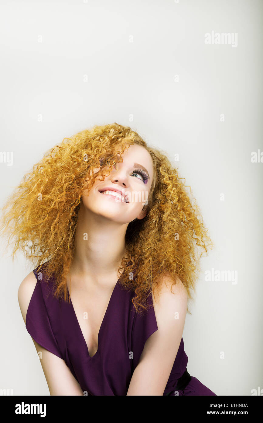 Stile di vita. Radiant donna felice con ricci capelli dorati sorridente. Emozioni positive Foto Stock