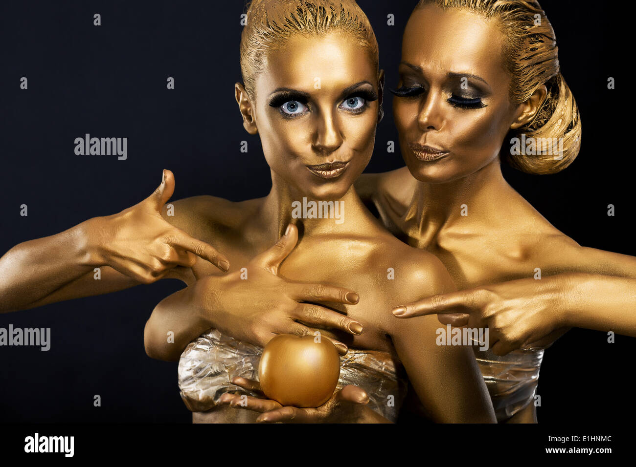 Masquerade. Il divertimento. Due donne lucido con corpo dorato Art. Il glamour Foto Stock
