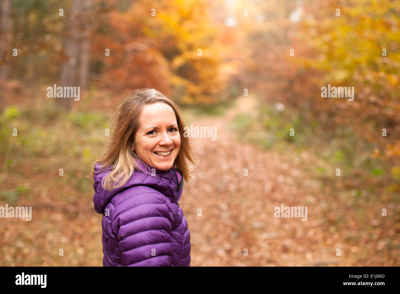 30-35 donna a passeggiare nel bosco in autunno, Northumberland, Inghilterra Foto Stock