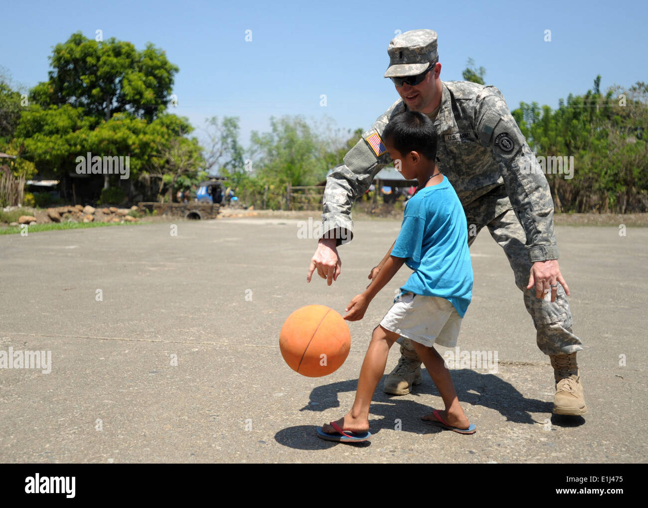 Stati Uniti Esercito 1Lt. Andrew Baughman, assegnati al 6° Battaglione ingegnere, gioca a basket con un ragazzo nel villaggio Manggahan, Ph Foto Stock