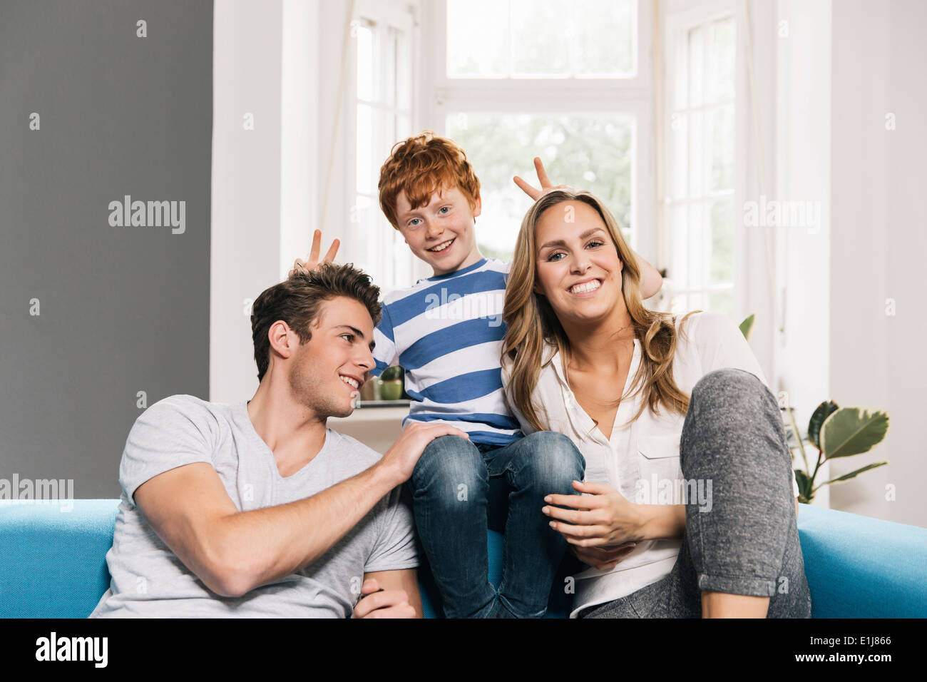 Ritratto di giovane famiglia seduti sul proprio divano in soggiorno Foto Stock