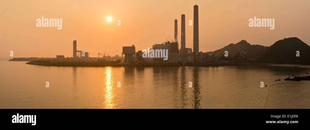 Cina, Hong Kong, Lamma Island, tramonto su un impianto alimentato a carbone in Yung Shue Wan bay Foto Stock