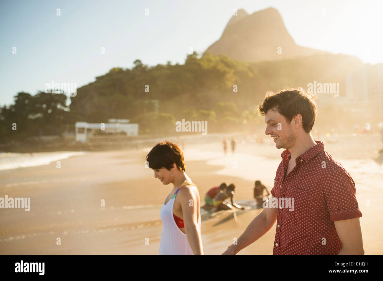 Coppia giovane godendo del tramonto, la spiaggia di Ipanema, Rio, Brasile Foto Stock