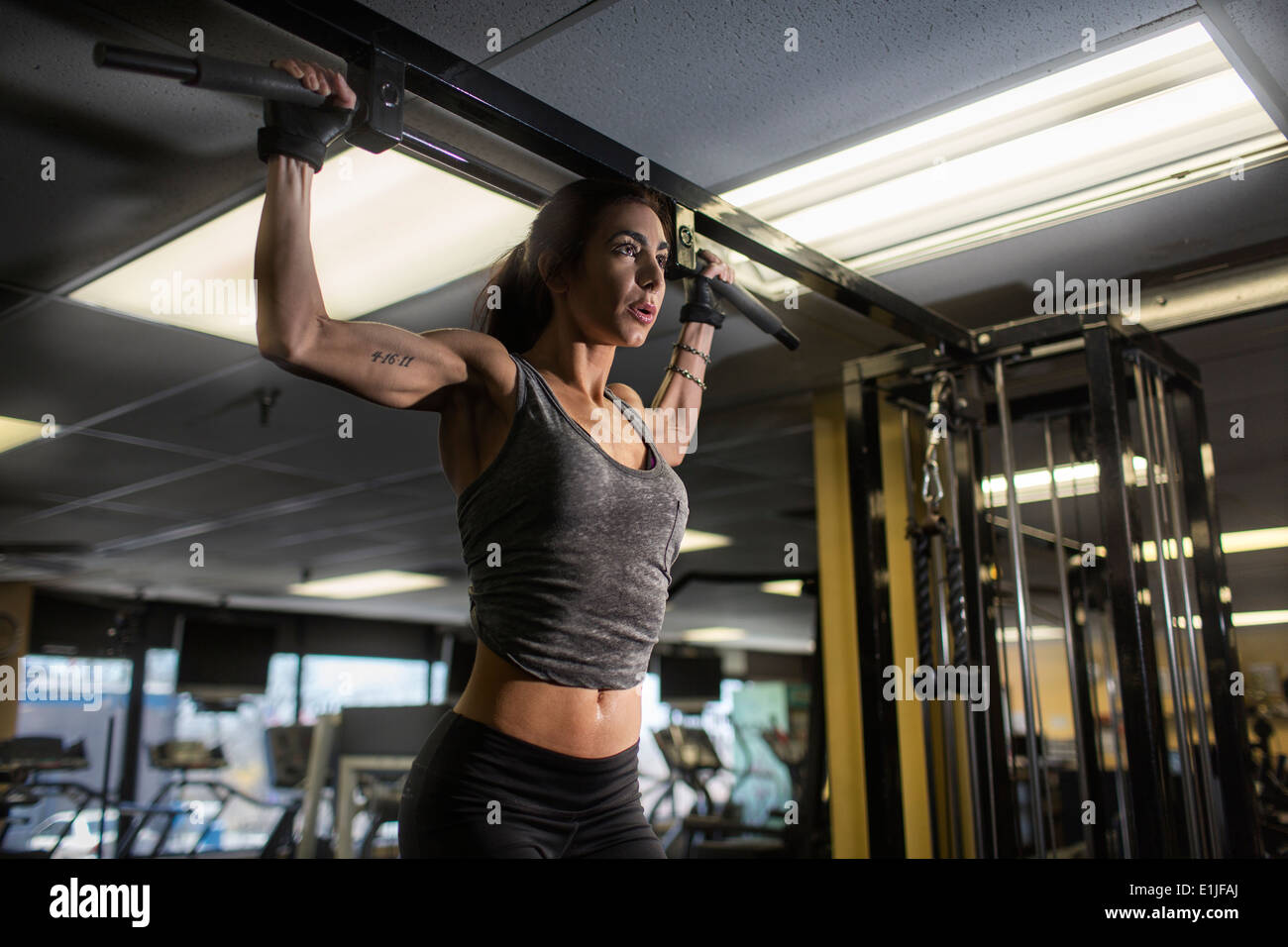 Metà donna adulta facendo esercizio pettorali in palestra Foto Stock