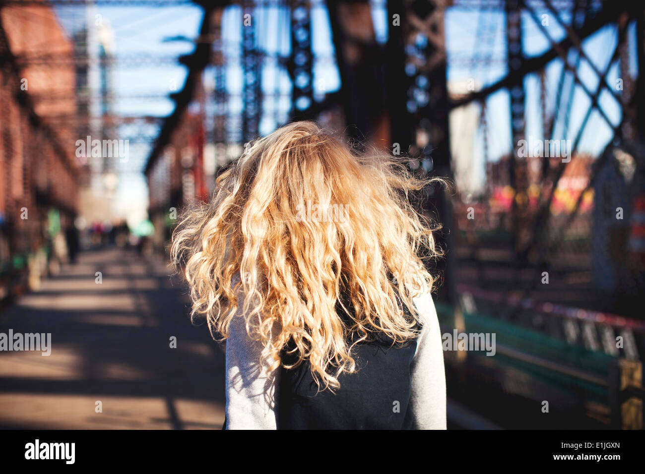 Giovane donna camminando sul ponte Foto Stock