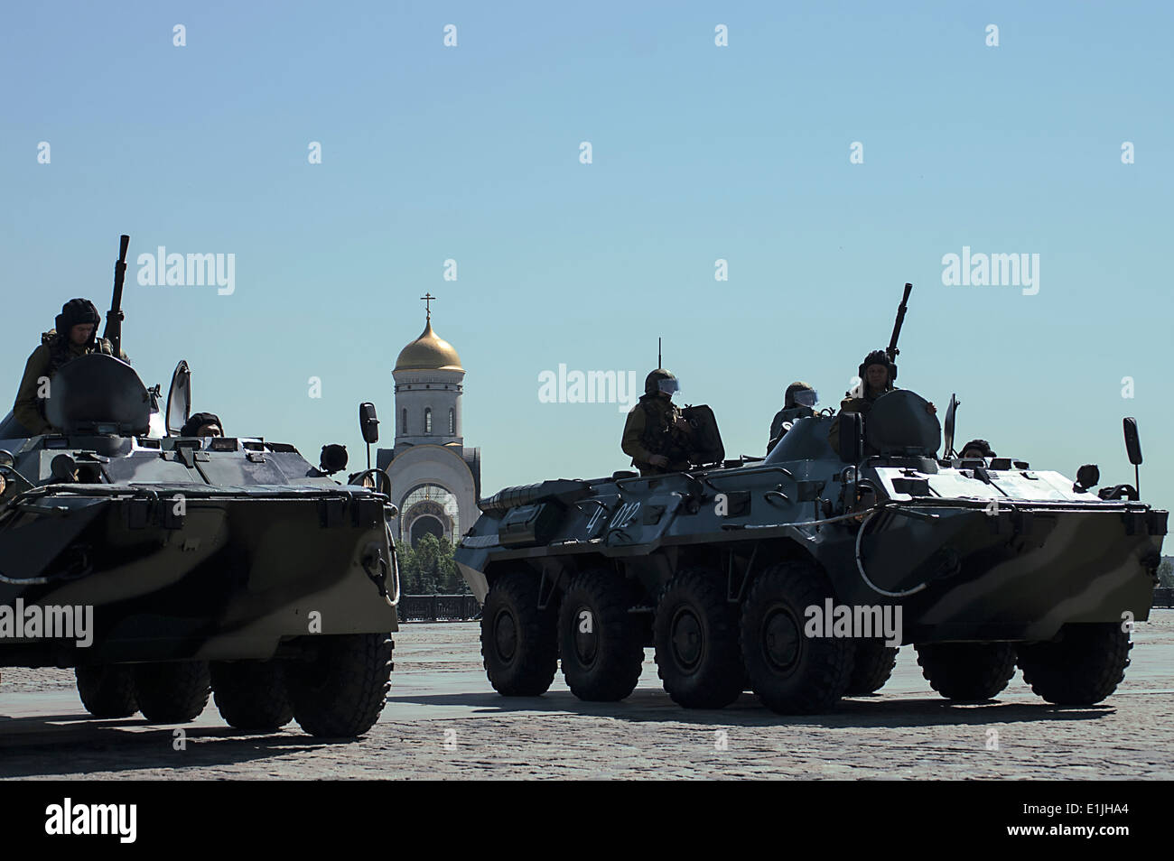 Soldati russi in camuffamento su le corazzate veicoli militari e la chiesa ortodossa in uno sfondo Foto Stock