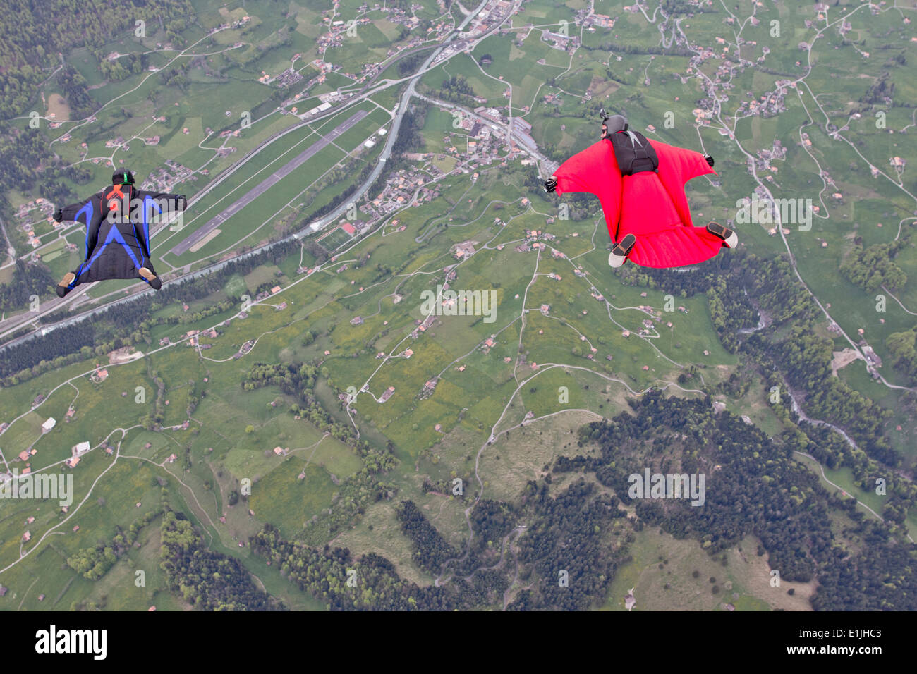 Due uomini che volano sopra i campi in wingsuits Foto Stock