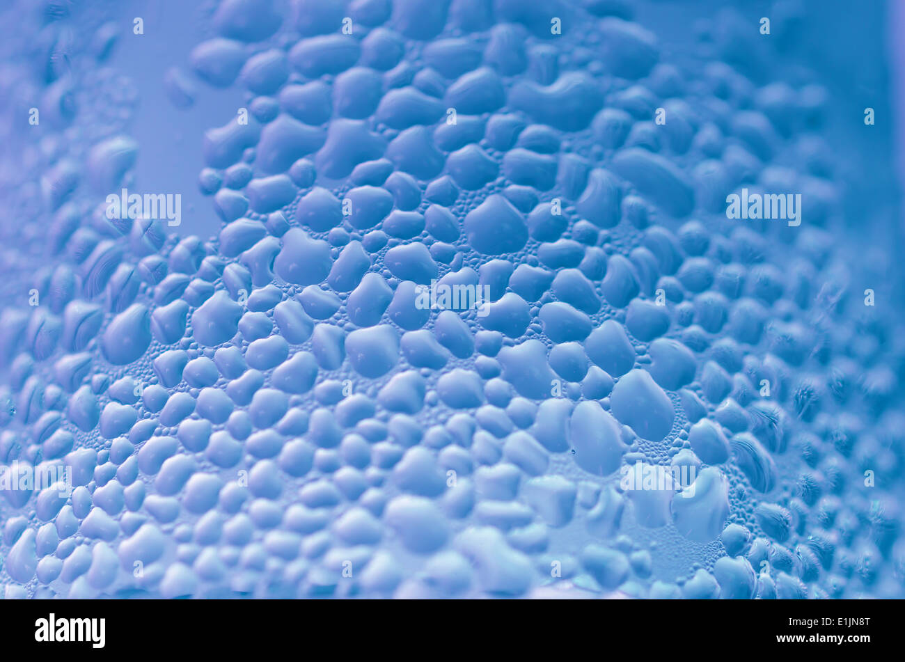 Le goccioline di acqua sul vetro con uno sfondo colorato. Gocce di acqua. Foto Stock