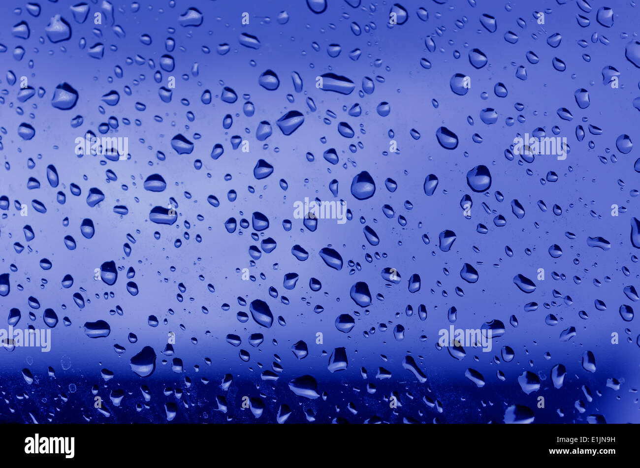 Le goccioline di acqua sul vetro con uno sfondo colorato. Gocce di acqua. Foto Stock