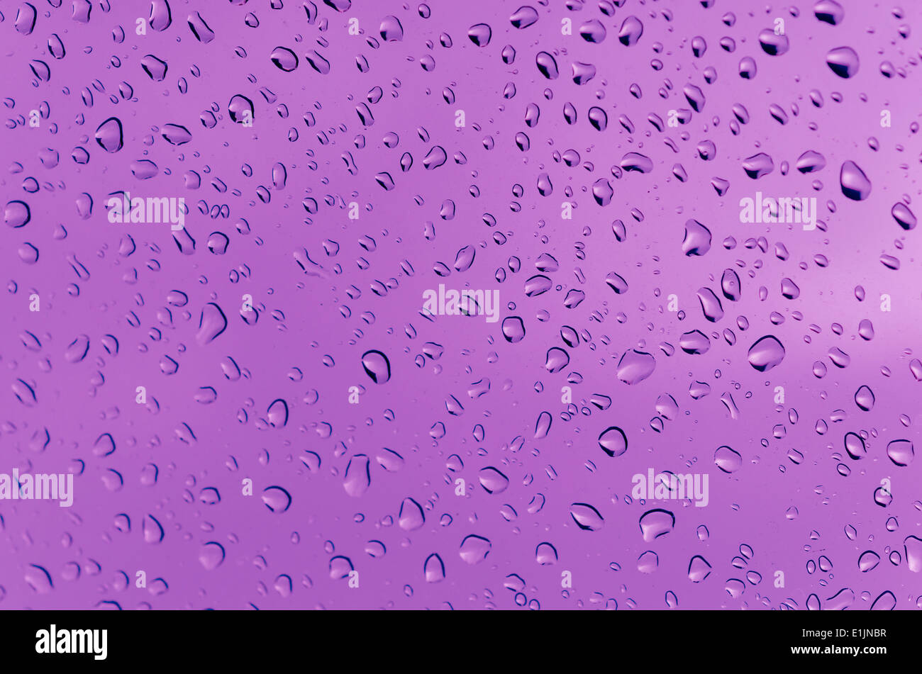 Le goccioline di acqua sul vetro con uno sfondo colorato. Gocce di acqua. Foto Stock