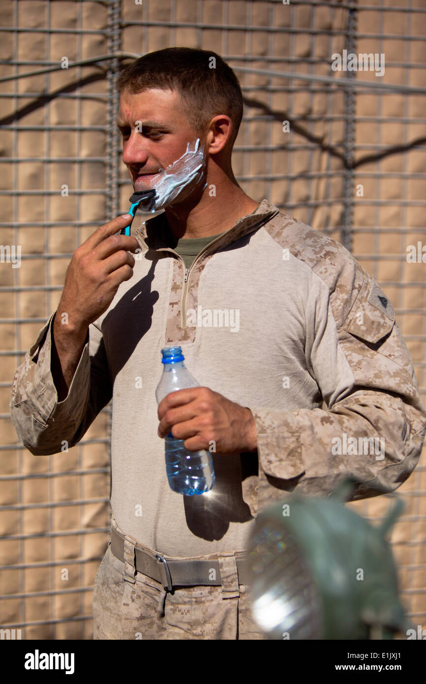 Un U.S. Marine con logistica di combattimento reggimento 2, del comando regionale del sud-ovest rade con un rasoio e una bottiglia di acqua in marcia avanti Foto Stock