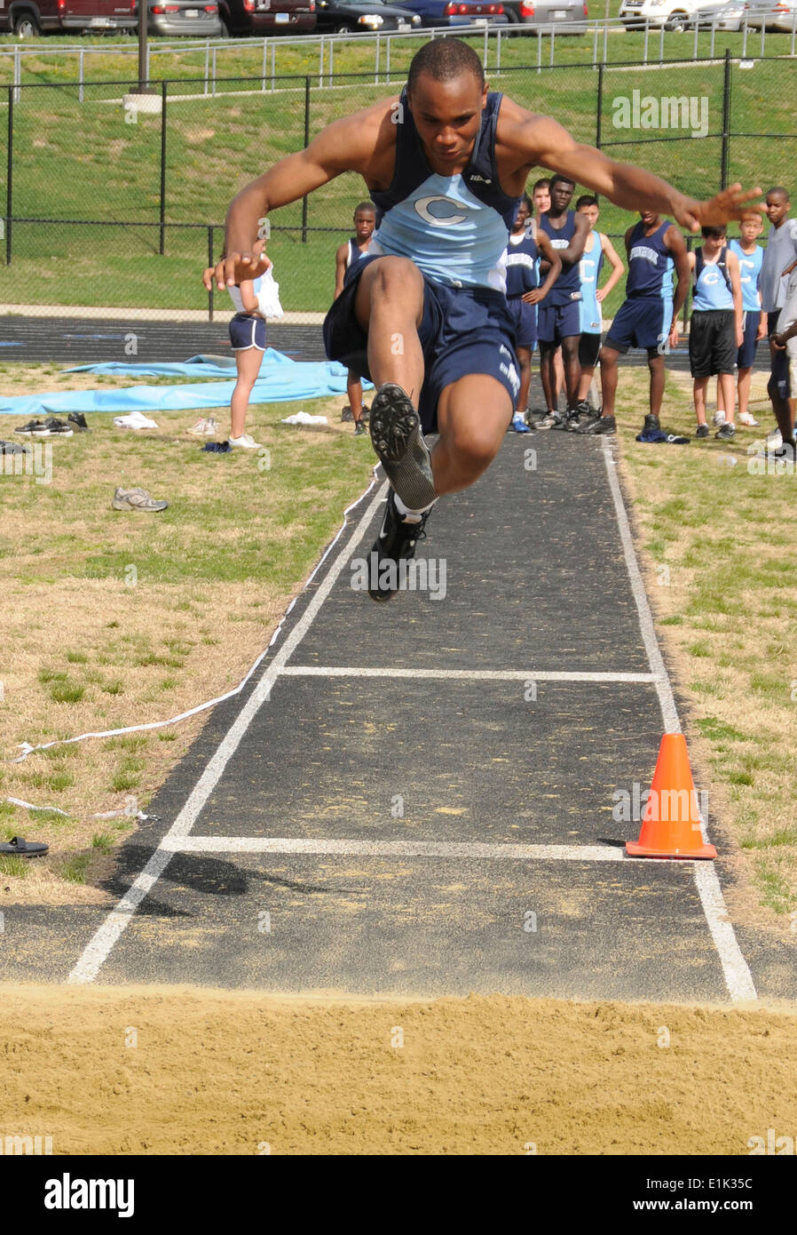 Teen facendo un salto in lungo in una via e il campo eventi Foto Stock