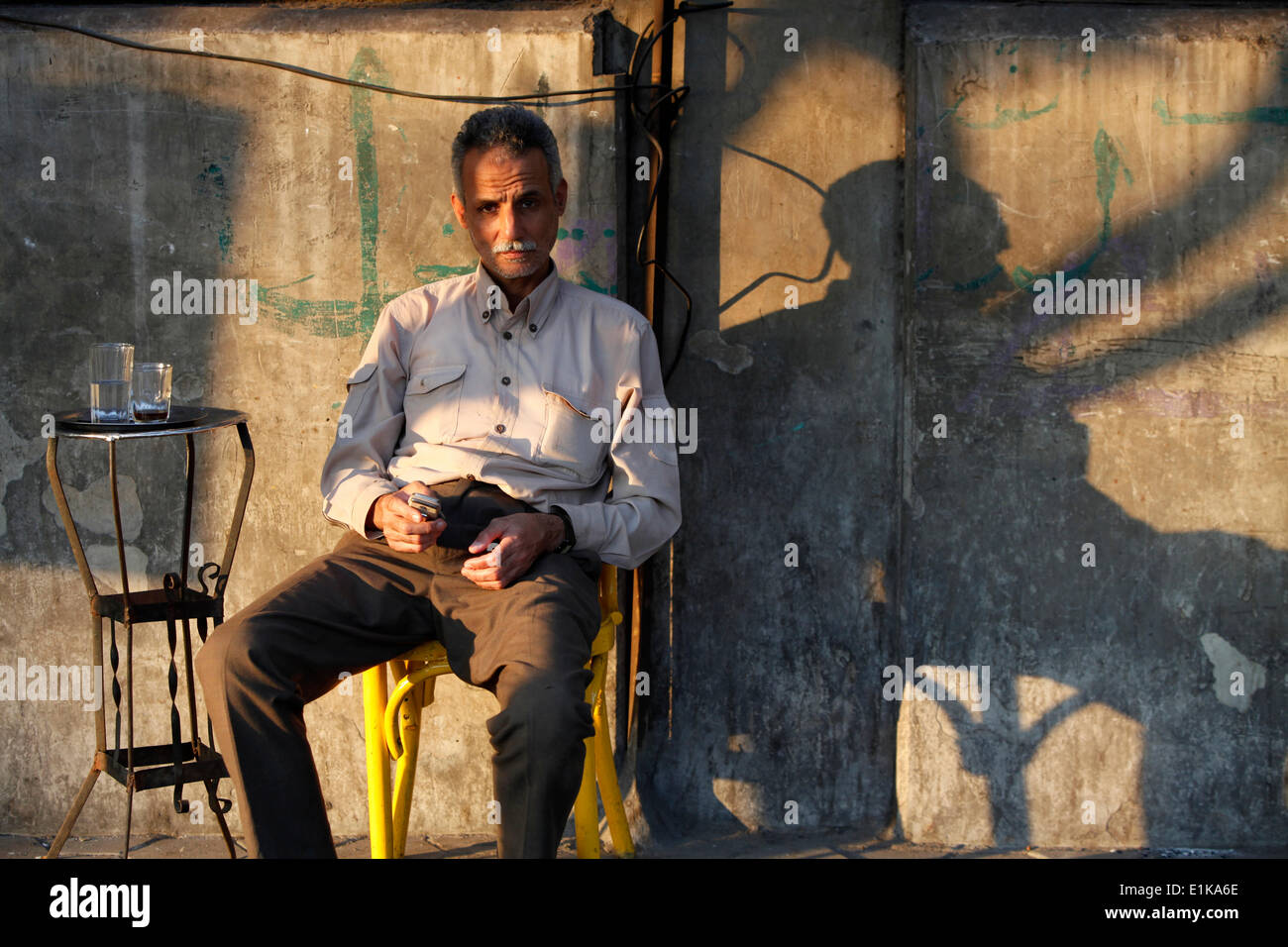 Uomo seduto al di fuori di un cafŽ Foto Stock