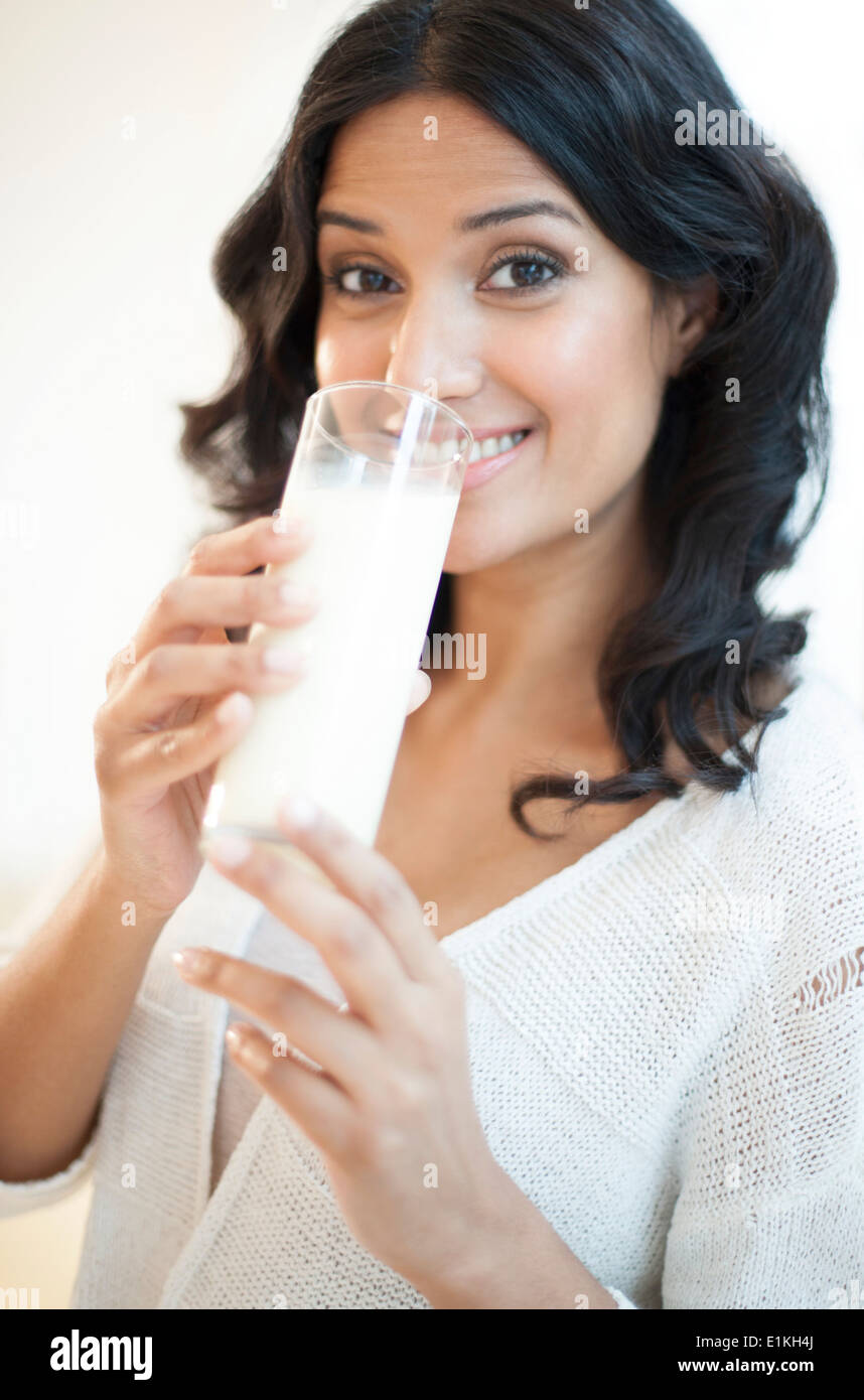 Modello rilasciato il ritratto di una donna di bere un bicchiere di latte. Foto Stock