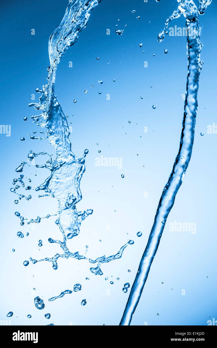 L'acqua che cade contro uno sfondo blu. Foto Stock