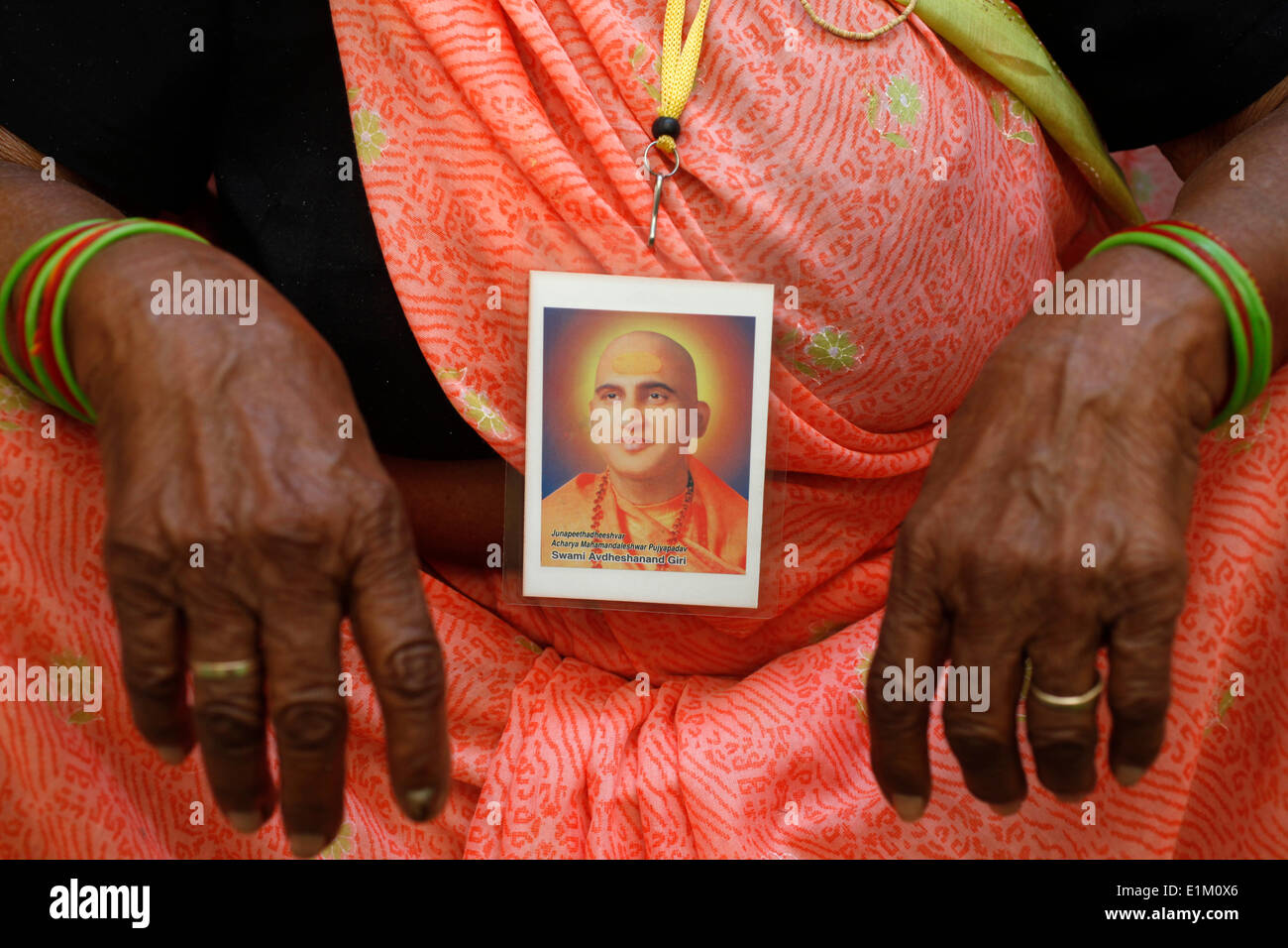 Devoto indossando un ritratto del leader spirituale Swami Avdeshanand Giri Foto Stock