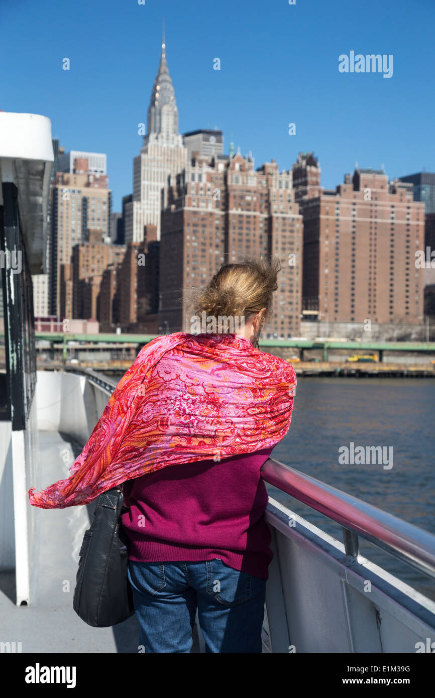 Una giovane donna che viaggia per lavoro sulla East River Ferry, NYC Foto Stock