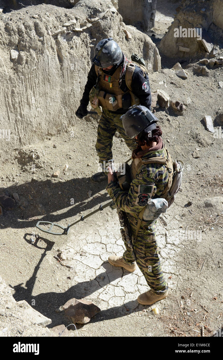Forze di sicurezza nazionali afgane membri con un villaggio Paktika unità di risposta per la ricerca di ordigni esplosivi artigianali e arma Foto Stock