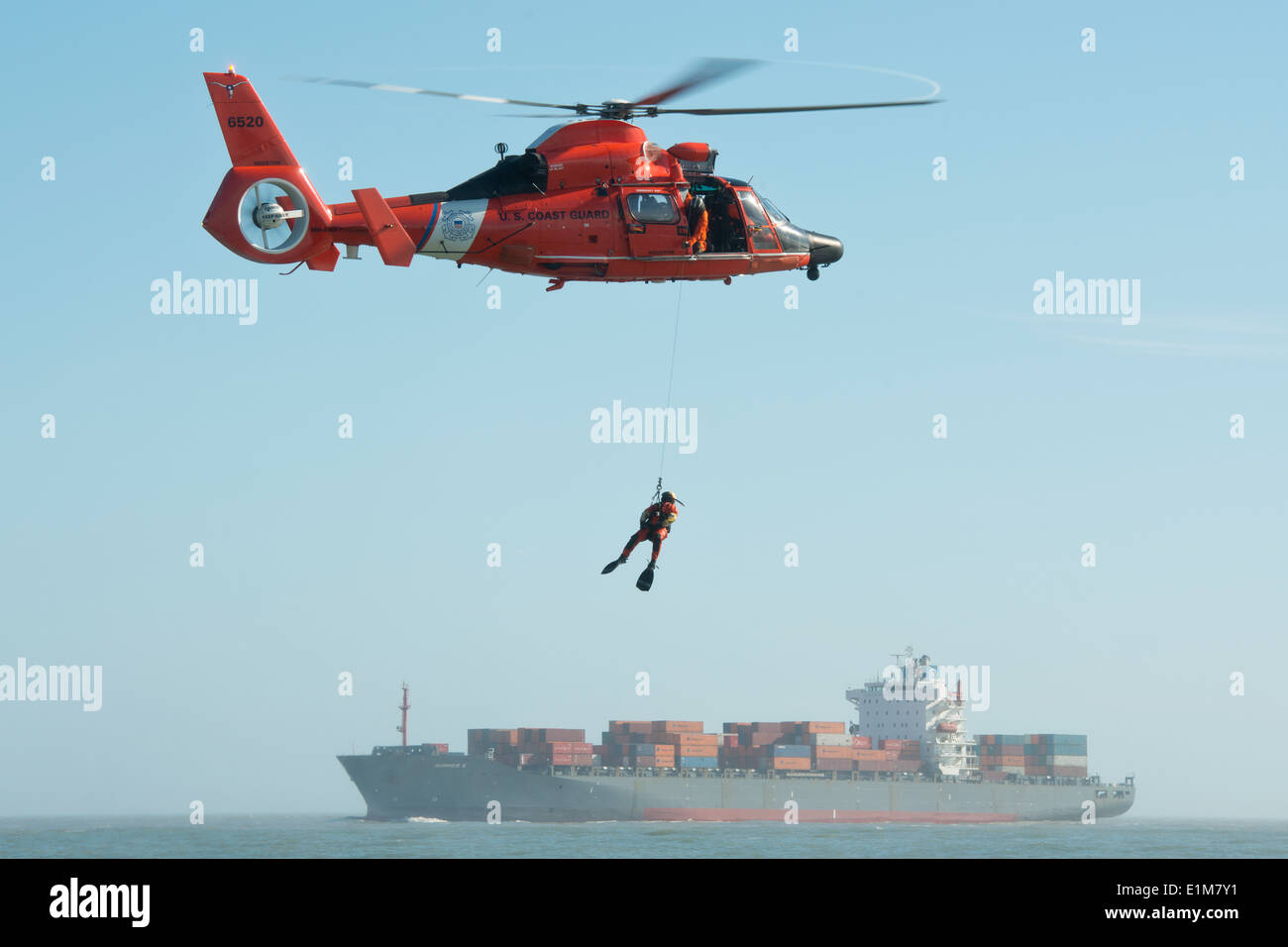 Stati Uniti Coast Guard Petty Officer di terza classe Andrew Wilson, un nuotatore di salvataggio con stazione aria Houston, pende da un HH-65 Dolphi Foto Stock