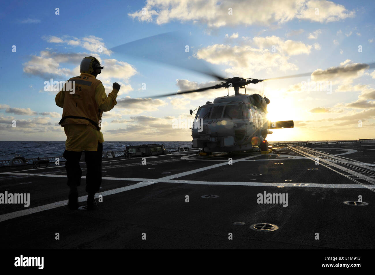 Stati Uniti Marina di Boatswain Mate 2a classe Robert Tito dà segnali a mano per una SH-60B Seahawk elicottero sul ponte di volo dell' Foto Stock