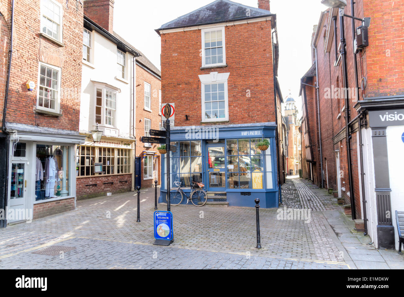 I piccoli negozi di alimentari indipendenti e molto stretti passaggi medievali nella storica città mercato di Ludlow Foto Stock