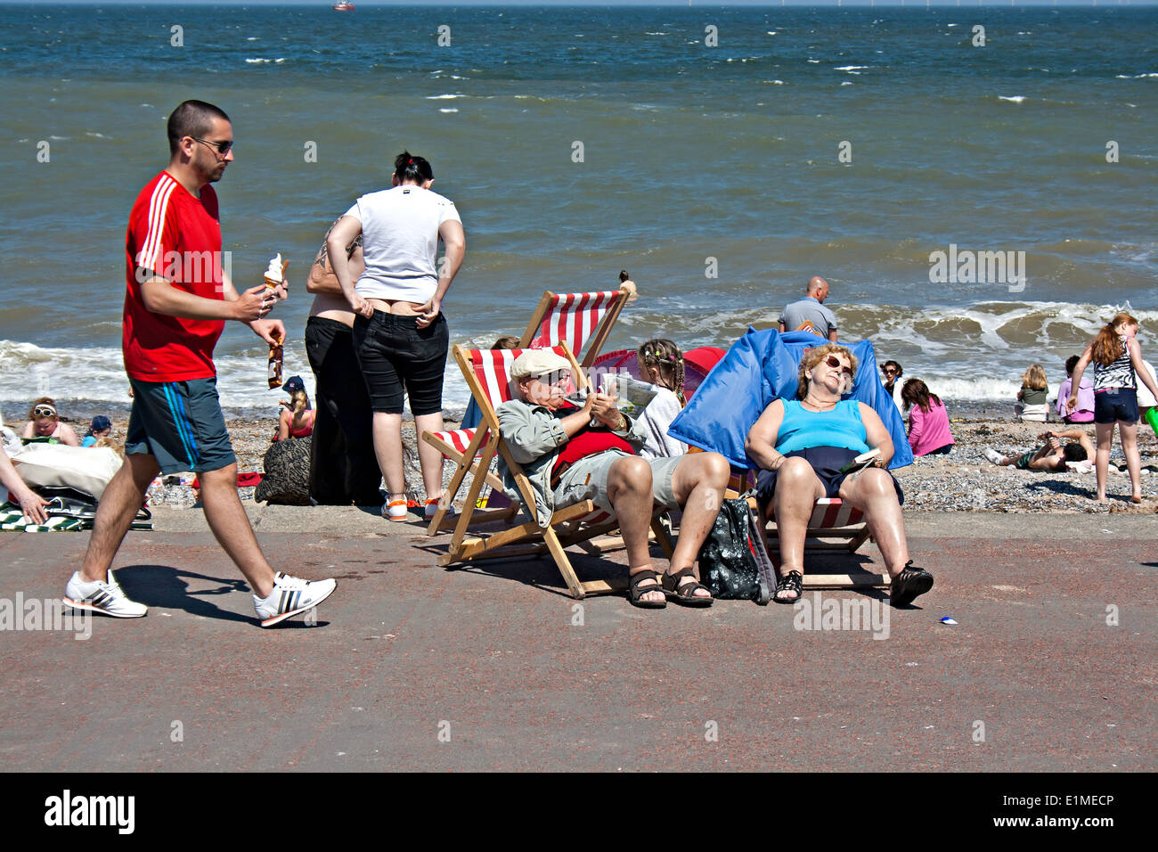 Coppia di anziani a prendere il sole in British seaside resort Foto Stock