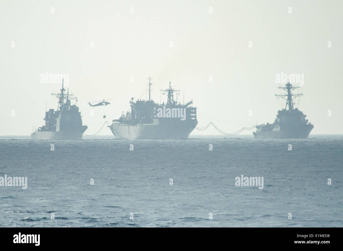 Il combattimento veloce nave appoggio USNS Arctic (T-AOE 8), centro conduce a una ricostituzione in mare con il missile cruiser USS Foto Stock