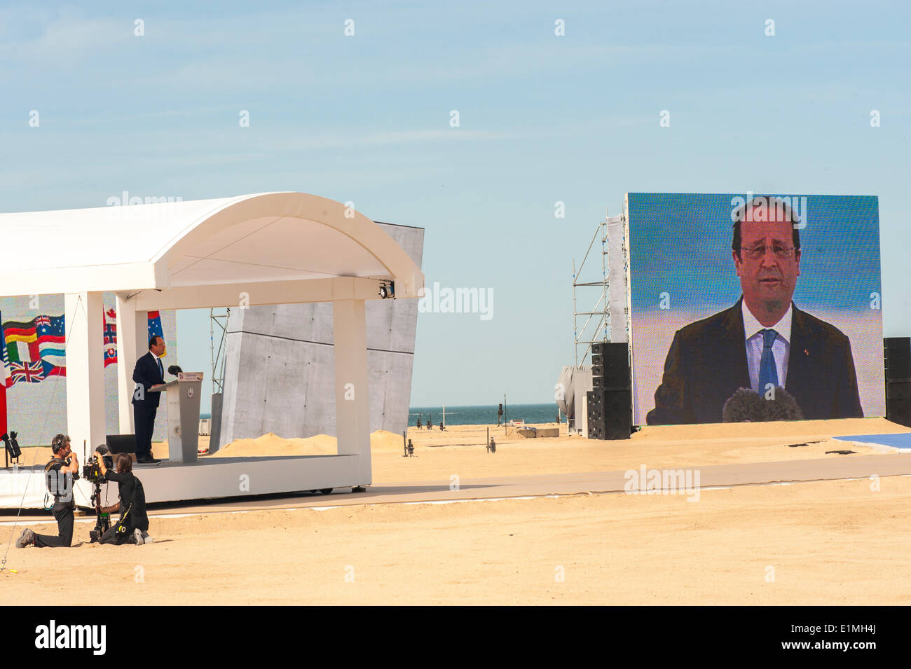 Ouistreham, spada Beach, in Normandia, Francia, il settantesimo anniversario del D-Day invasione, Presidente francese Francois Hollande dare la parola con schermo Foto Stock