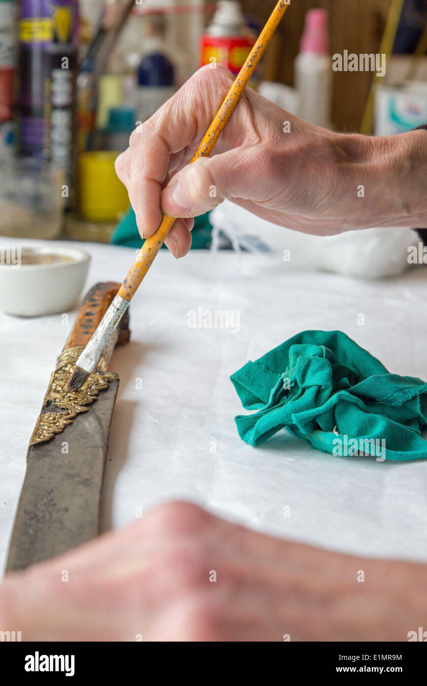 Restauro di vecchi spada turco - dettaglio della mano durante il lavoro Foto Stock