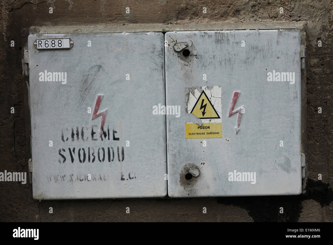 Cassetta elettrica con un simbolo di alta tensione e graffiti in ceco 'Vogliamo Libertà!" in Kutna Hora, Repubblica Ceca Foto Stock