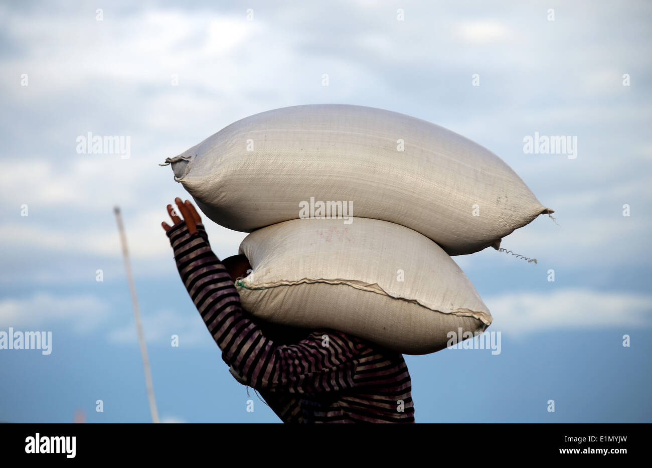 Yangon, Myanmar. Il 6 giugno, 2014. Un lavoratore svolge due sacchetti di risotti al jetty di fiume Yangon di Yangon, Myanmar, Giugno 6, 2014. © U Aung/Xinhua/Alamy Live News Foto Stock