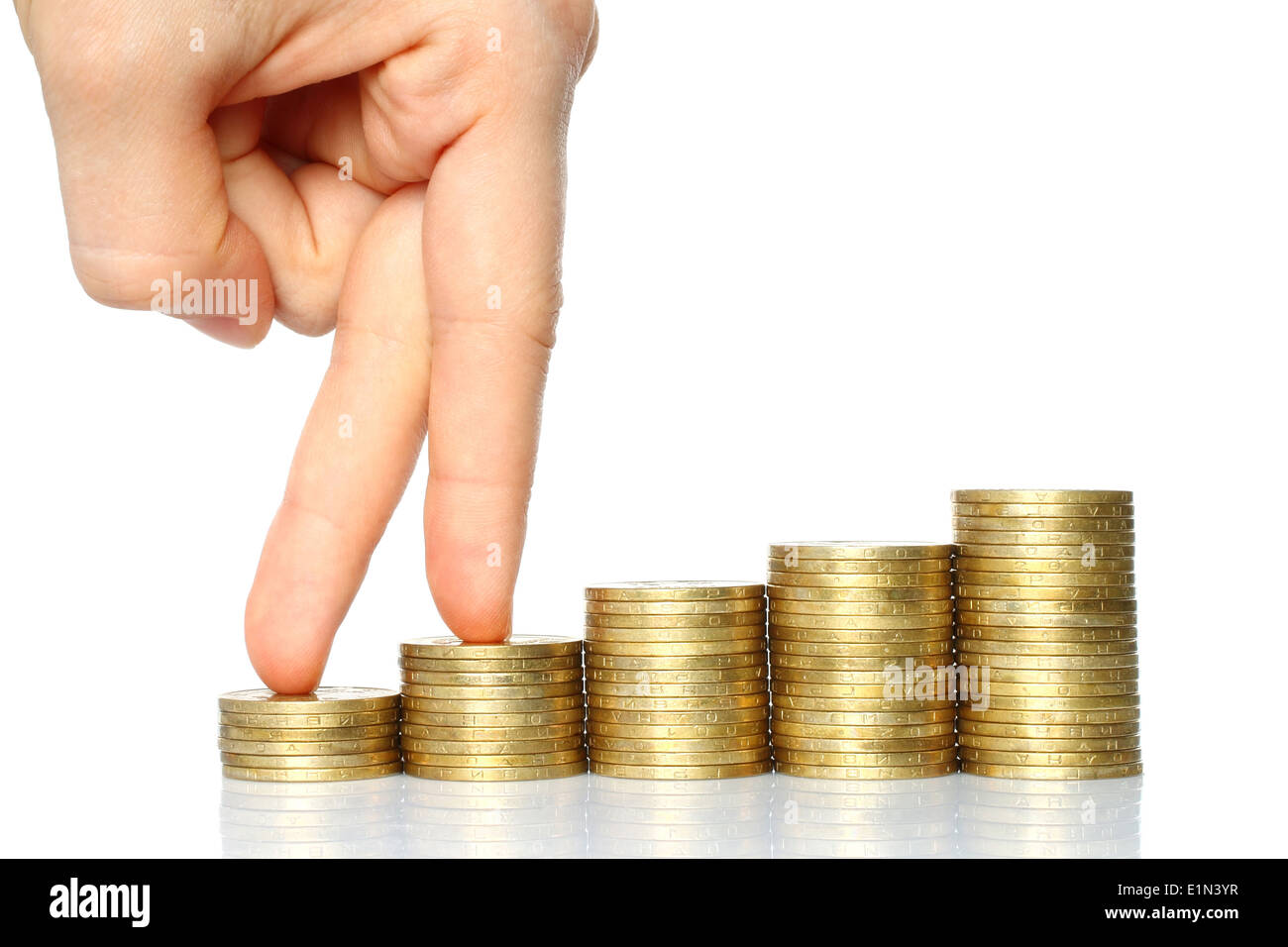 Dita fino a piedi su pile di monete su sfondo bianco. Il concetto di crescita Foto Stock