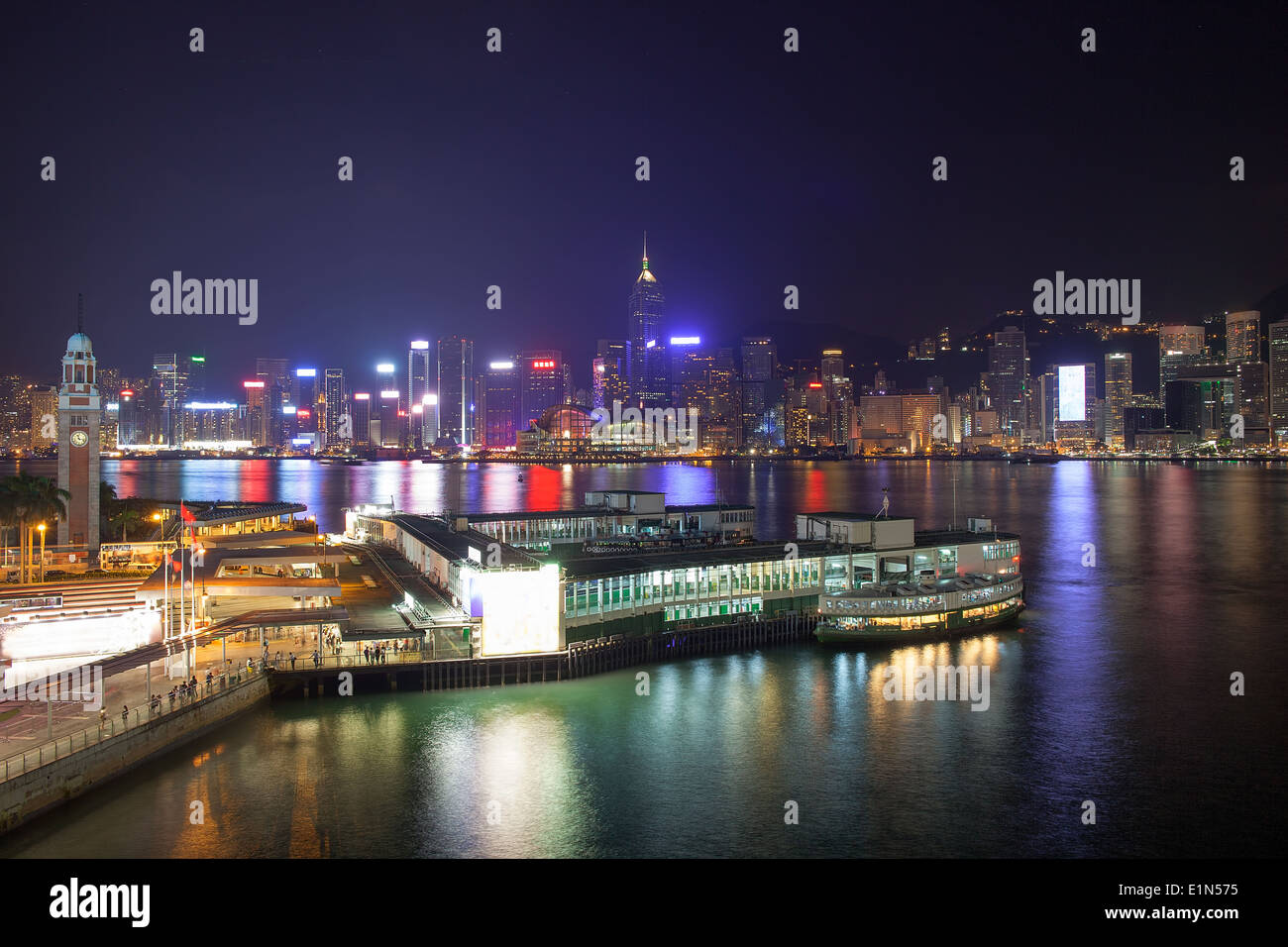 Kowloon Ferry Pier a Tsim Sha Tsui con Isola di Hong Kong Central City skyline notturno Foto Stock